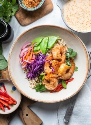 Thai-style Shrimp Bowls with brown rice, red cabbage, red onions, carrots, and snow peas served with Spicy Coconut Dressing on the side.
