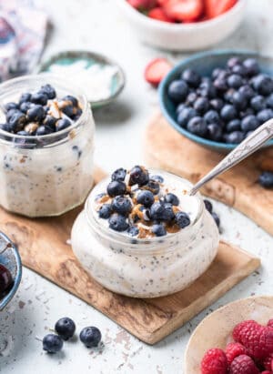Blueberry Muffin Overnight Oats with fresh blueberries, almond butter and coconut flakes in a jar.